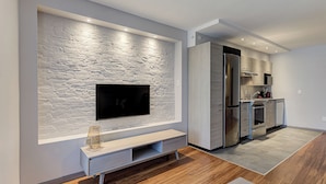 A modern kitchen with a built-in refrigerator, a microwave, and a sink. - 77 St-Vallier Appart Hôtel (Québec)