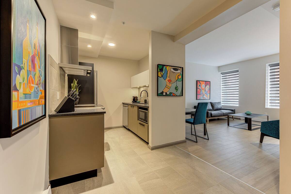 A modern apartment with a kitchen, dining area, and living room.