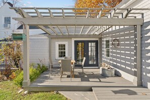 Relax in the shaded patio area with a comfortable seating arrangement and a touch of greenery.
