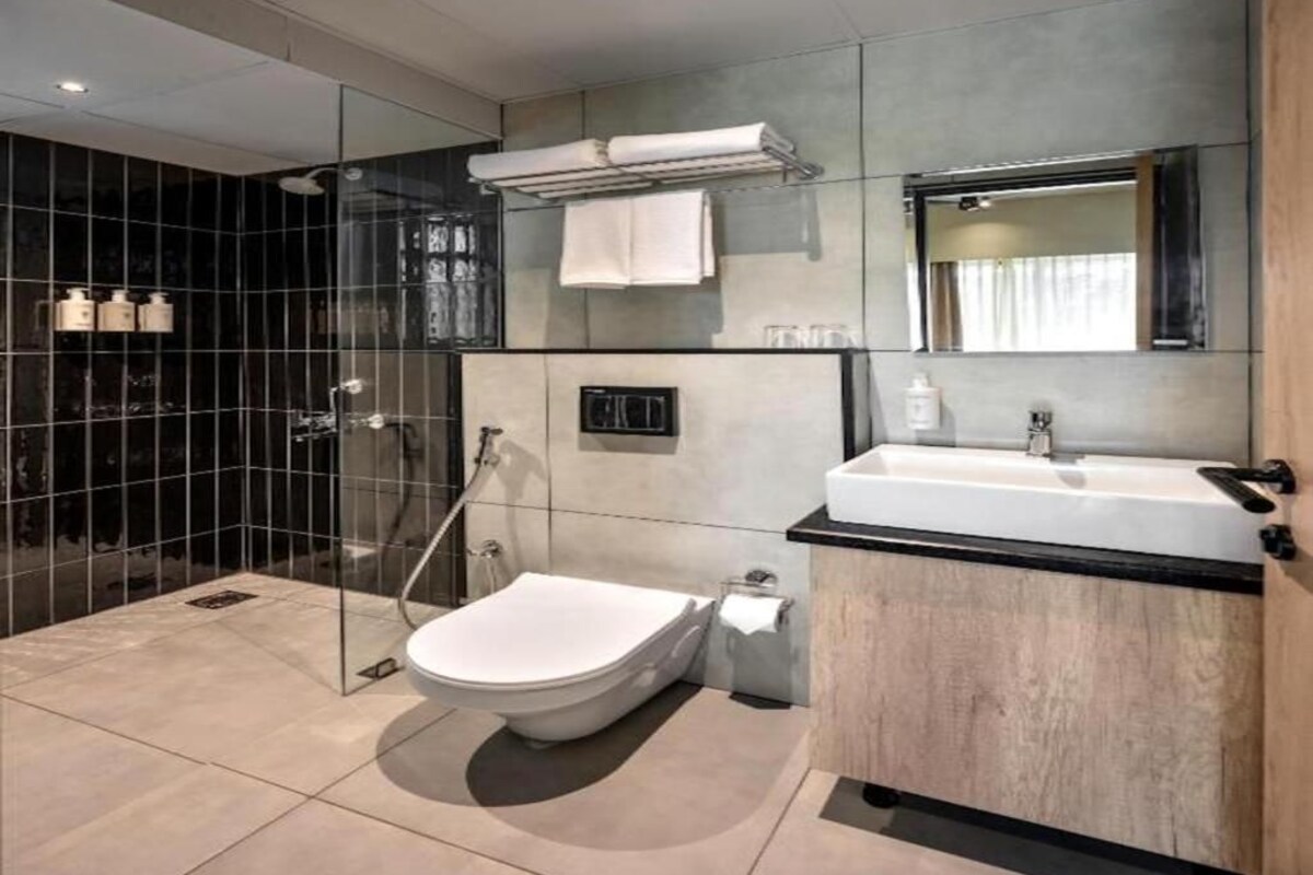 Une salle de bain moderne avec une douche à parois de verre, des toilettes et un meuble-lavabo avec un évier.