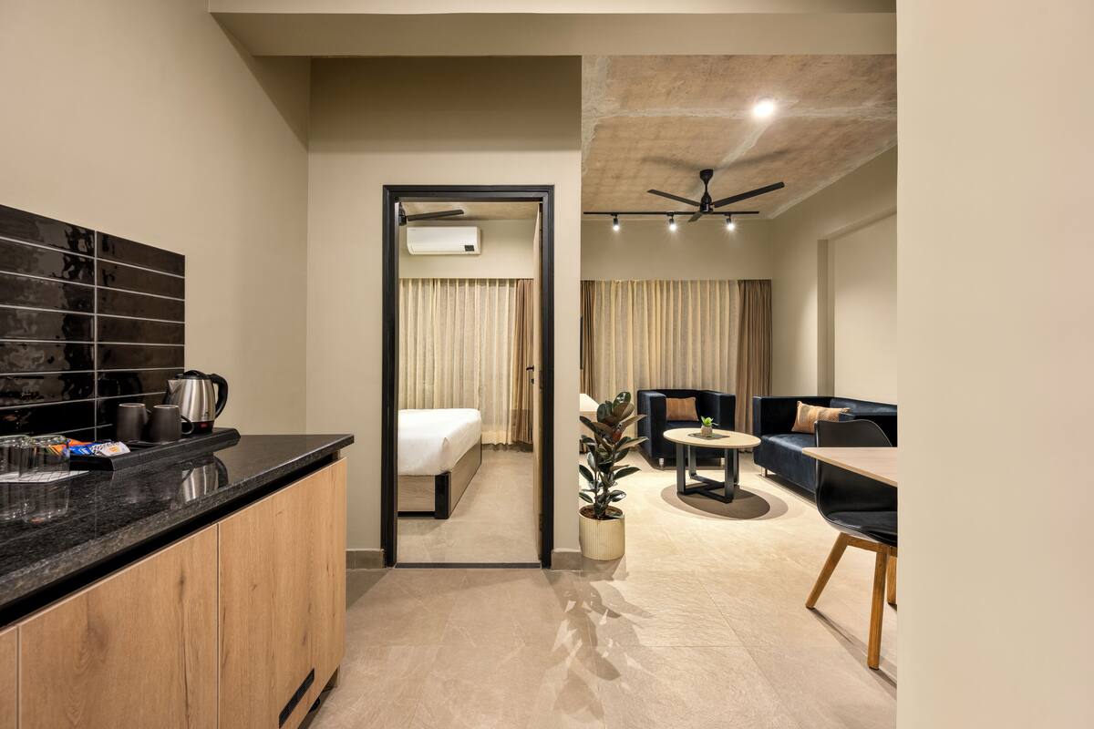 Une chambre d’hôtel moderne dotée d’une cuisine, d’un coin repas et d’un espace de vie.