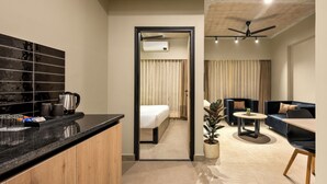 Une chambre d’hôtel moderne équipée d’un coin cuisine, d’une table à manger, d’un canapé et d’un lit.