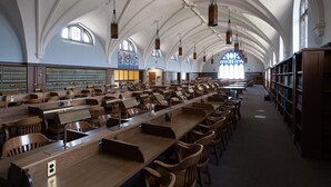 A spacious library with high arched ceilings and rows of wooden tables and chairs. - Hotel Wolfe Island (Wolfe Island)