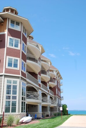 Ein mehrstöckiges Hotel mit Balkonen, einer Steinfassade und Blick auf den Strand.