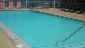 Une piscine avec des chaises longues et vue sur l’océan.