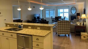 A modern kitchen with granite countertops, stainless steel appliances, and pendant lighting. - Lovely 2-bedroom Suite with lots of Amenities (Traverse City)