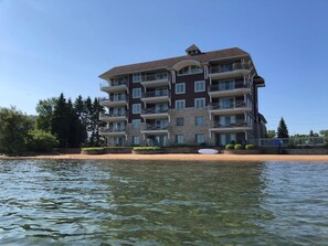 A multi-story hotel with balconies, located near a body of water. - Beautiful views from Fifth Floor Suite (Traverse City)