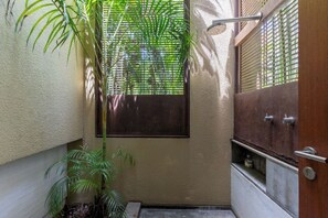A small, enclosed bathroom with a shower, a door, and a window. - Yeguas Y41 by Wynwood House  (Anapoima)
