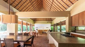 A spacious kitchen with a central island, large windows, and a thatched roof. - Yeguas Y41 by Wynwood House  (Anapoima)