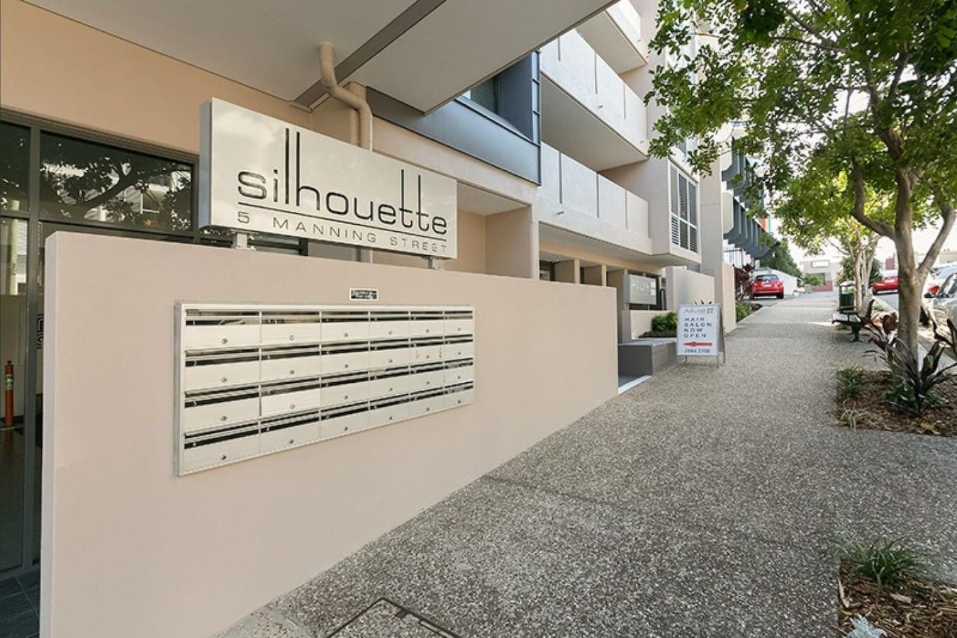 A building with a sign reading 'Silhouette 5 Manning Street' and a mail slot on the wall.