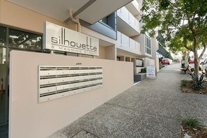 A building with a sign reading 'Silhouette 5 Manning Street' and a mail slot on the wall.