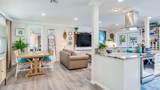 A modern kitchen with a central island, built-in appliances, and a dining area with a wooden table and chairs. - Heated pool on water, 3-bedroom house in beautiful Tampa (Tampa)