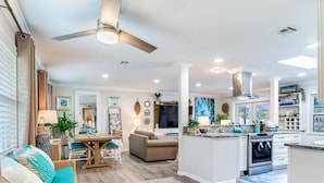 A spacious living area with a dining table, sofa, and kitchen island. - Heated pool on water, 3-bedroom house in beautiful Tampa (Tampa)