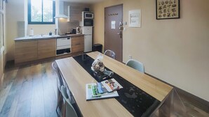 A modern kitchen with a dining area, wooden cabinets, a microwave, and a refrigerator. - Amazing apartment in Saint Chinian (Saint Chinian)