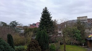 A residential garden with a variety of trees, a lawn, and a brick pathway. - Vacation apartment "Schöne Aussicht" with large balcony-terrace (Nordenham)