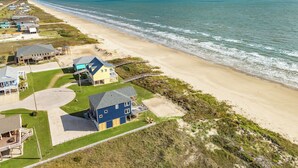 Luchtbeeld van een kustgebied met woonhuizen, een strand en de oceaan.