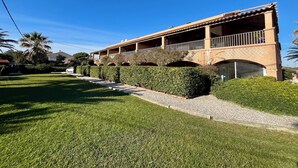 Un bâtiment à deux étages doté d’un patio couvert et d’une pelouse aménagée.