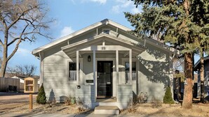 A single-story house with a gabled roof and a front porch. - New! Charming private home in historic district. Short walk to downtown Rapid City. Well-appointed and newly renovated. King bed, fireplace, dishwasher, washer/dryer, Wi-Fi, EV charger, tiled shower. Off-street parking. Easy access to I-90. (Rapid City)