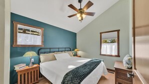 A bedroom with a bed, bedside tables, a ceiling fan, and windows with curtains. - New! Charming private home in historic district. Short walk to downtown Rapid City. Well-appointed and newly renovated. King bed, fireplace, dishwasher, washer/dryer, Wi-Fi, EV charger, tiled shower. Off-street parking. Easy access to I-90. (Rapid City)