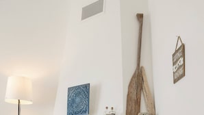 A fireplace with a mantel, a standing lamp, and a wicker basket with logs.