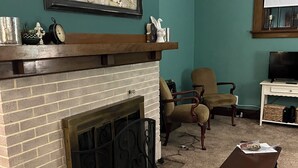 A living room with a fireplace, a television, and a large abstract painting. - Cheerful home away from home in welcoming Wausau!  (Wausau)