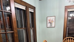 A dining area with a wooden table and chairs, a patterned rug, and a window with blinds. - Cheerful home away from home in welcoming Wausau!  (Wausau)