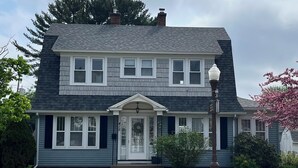 A two-story house with a front porch, a mailbox, and a street lamp. - Cheerful home away from home in welcoming Wausau!  (Wausau)