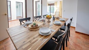 A dining table set with plates, glasses, and a centerpiece.