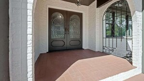 A white brick entrance with a glass door and a metal gate. - Pool, Beaches, OWA, Dining, and More | Palmaway (Foley)