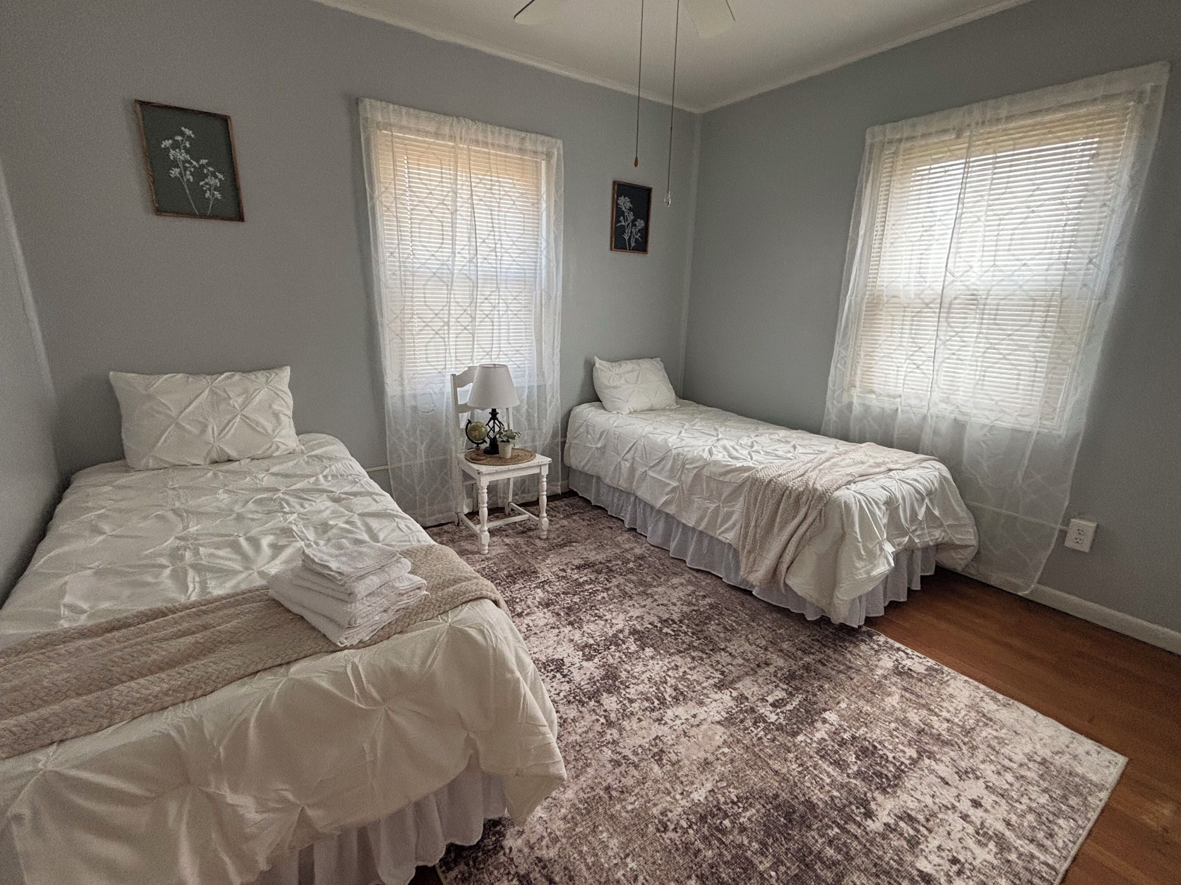 Une chambre avec deux lits, une petite table et un tapis.