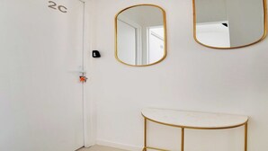 A room with a white door labeled '2C', a gold-framed mirror, and a gold-framed vanity table.