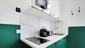A compact kitchen with a built-in microwave, toaster, and sink.