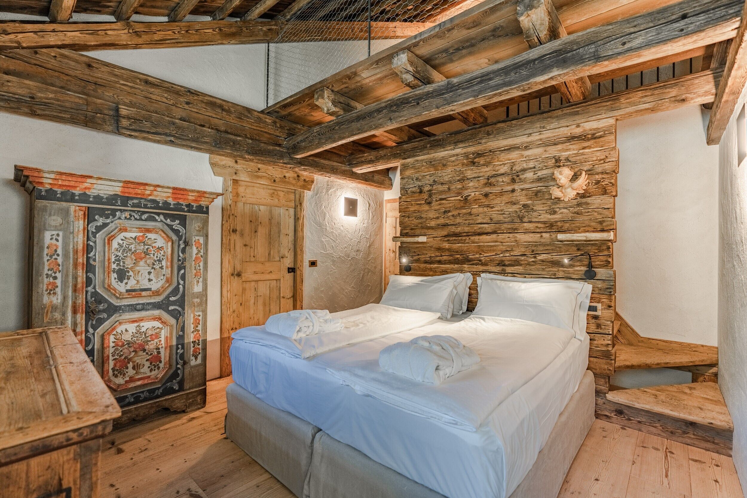 Une pièce rustique en bois, avec un lit, une armoire en bois et un panneau décoratif mural.