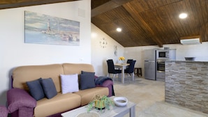 A cozy living room with a sofa, a coffee table, and a painting on the wall. - Holiday Home 'Ro' with Private Pool, Wi-Fi and Air Conditioning (Conil de la Frontera)