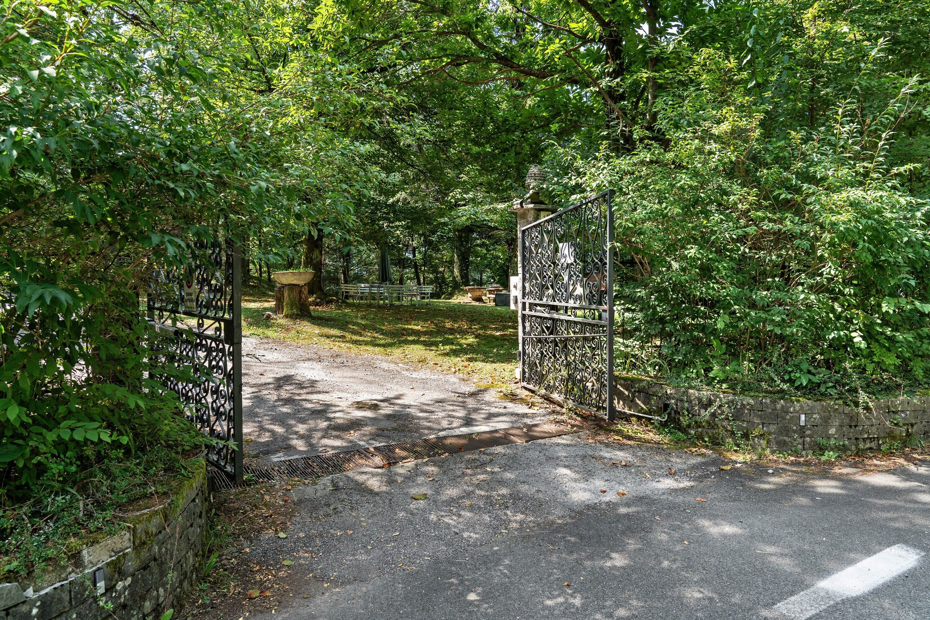 A gated entrance to a park with a paved path leading through it.