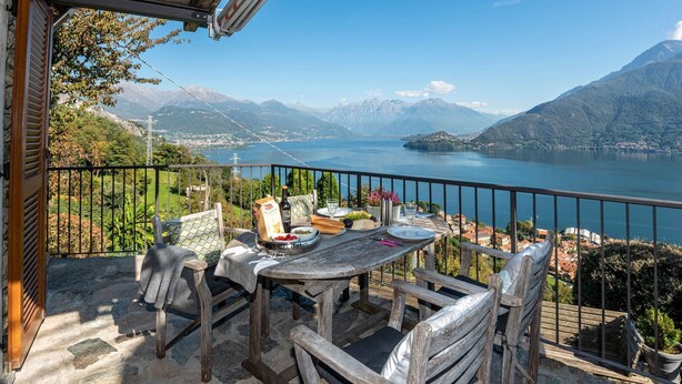 A terrace with a table set for two, overlooking a lake and mountains. - Holiday Home 'Casa Bianca' with Lake View, Private Terrace and Wi-Fi (Saliana (Pianello del Lario))
