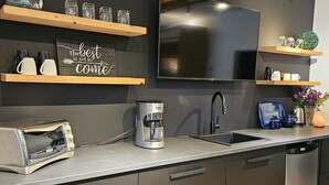 Une cuisine moderne équipée d’un four encastré, d’une machine à café, d’un grille-pain et d’un évier.