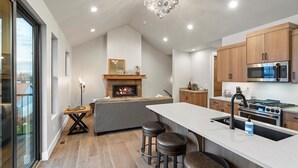 Une cuisine moderne dotée d’un îlot central, de meubles en bois et d’un four encastré.