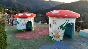 Deux structures en forme de champignons, ornées de texte, et offrant une vue sur un paysage montagneux.