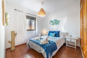 A bedroom with a bed, a bedside table, a wall-mounted light fixture, and a window with curtains. - Holiday Home 'La Casa Del Bosque' with Mountain Views, Balcony & Wi-Fi (Júzcar)