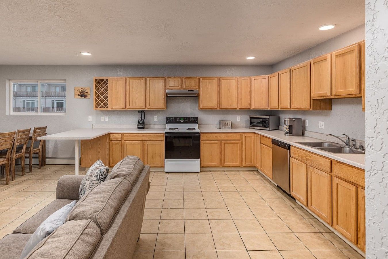 A compact kitchen with wooden cabinets, a stove, a microwave, and a dishwasher.