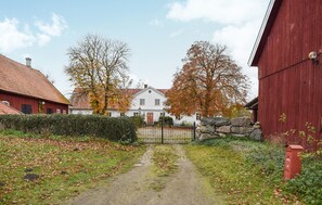 A rural pathway leading to a white house with a red barn on the right. - 2 bedroom amazing apartment in Everöd (Everöd)