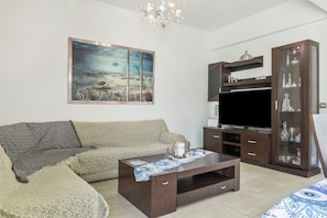 Sala de estar con sofá, mesa de centro, mueble para televisión y aparador.