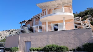 A multi-story building with a balcony and a door. - Nice apartment in Lukovo with house sea view (Lukovo)