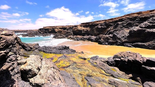 A rocky coastline with a beach and ocean.