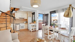 A modern apartment with a kitchen, dining area, and living room.