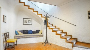 Eine Treppe mit Holzbodenstufen und einem Metallgeländer, die zu einer oberen Etage führt.