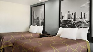 A hotel room with two beds, a cityscape view, and a modern design. - Crystal Inn Northeast Houston Downtown I-610 (Houston)