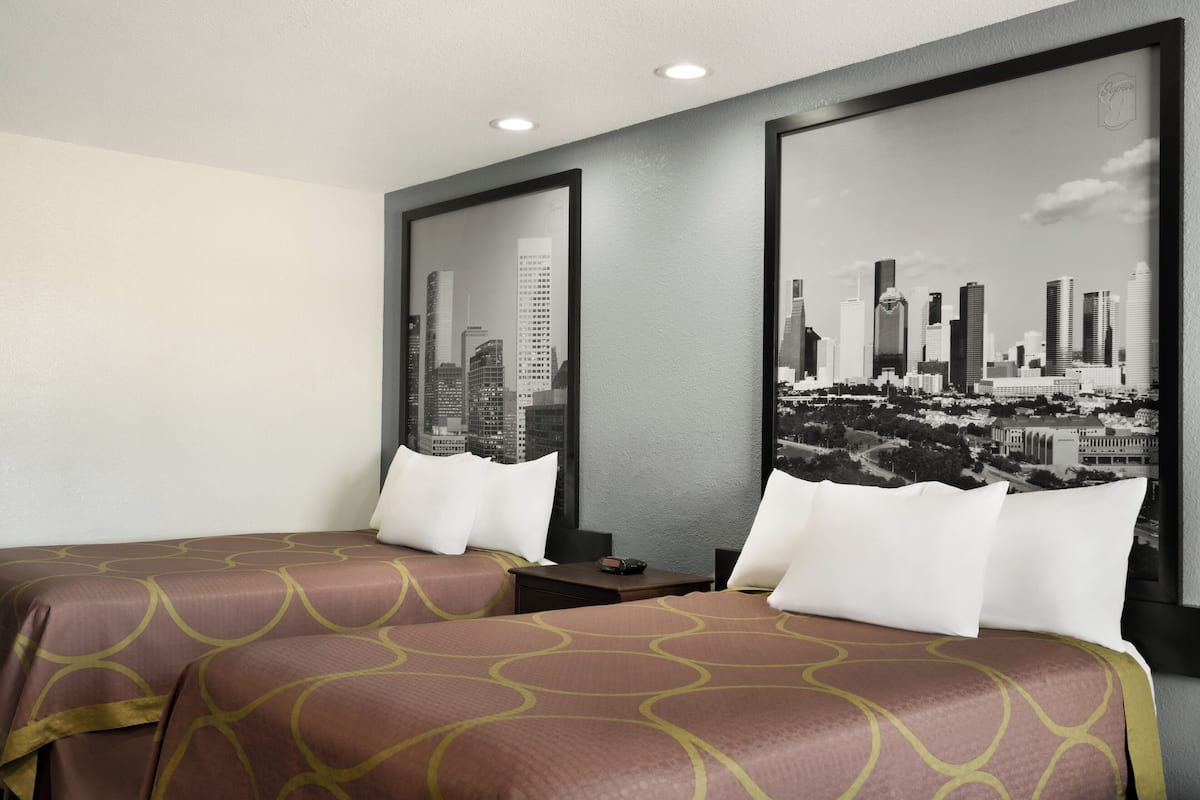 Habitación de hotel con dos camas, vistas a la ciudad y un diseño moderno.