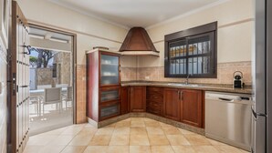 Una cocina con armarios de madera, lavavajillas y una ventana sobre el fregadero.